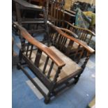 An Edwardian Oak Reclining Armchair with Barley Twist Supports, No Cushions and Requires Back Bar
