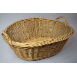 An Oval Wicker Clothes Basket with Two Handles, 65cm Long