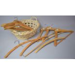 A Wicker Basket Containing Various Vintage Hotel Coat Hangers