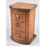 An Edwardian Novelty Puzzle Moneybox in the Form of a Bow Fronted Three Drawer Chest, the Top Drawer