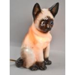 A Continental Porcelain Novelty Night Light in the Form of a Seated Cat with Blue Glass Eyes,