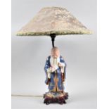 A Chinese Figural Table Lamp in the Form of Shou Lao Holding Peach of Longevity, Complete with Shade