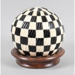 A Modern Reproduction Black and White Chequered Sphere on Turned Wooden Surround, 15cm Diameter