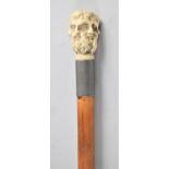 An Early Mid 20th Century Bamboo Sword Stick, The Handle Moulded in the Round with Six Masks of