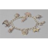 A Vintage Silver Charm Bracelet with Eight Charms to Include Horse, Cow, Bible, Articulated