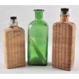 A Green Glass Bottle and Two Wicker Covered Glass Bottles, The Tallest 29cms High