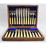 An Edwardian Oak Cased Canteen of Twelve Bone Handled Fish Knives and Forks