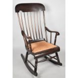 A Mid 20th century Spindle Back Rocking Chair with Upholstered Padded Seat