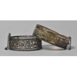 A Silver Bangle with Engraved Decoration and a White Metal Filigree Example