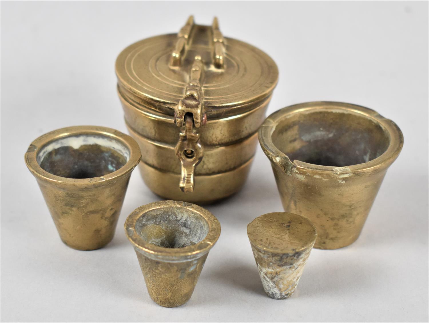 A Set of Four Cylindrical Tapering Graduated Brass Weights in Container with Hinged Lid, 5cms - Image 2 of 2