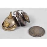 A Leather Pouch Containing a Miniature Novelty Charm in the Form of a German Helmet, Pig Charm and