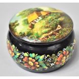 A Russian Circular Lacquered Box, the Lid Decorated with Thatched Cottage, the Body with Flowers,