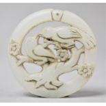 A Chinese White Jadeite Roundel with Pierced Decoration Depicting Birds in Tree, 5cm Diameter