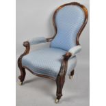 A Victorian Ladies Balloon Back Armchair with Carved Scrolled Supports Culminating in Casters