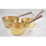 A Graduated Set of Three Brass Saucepans with Iron Handles