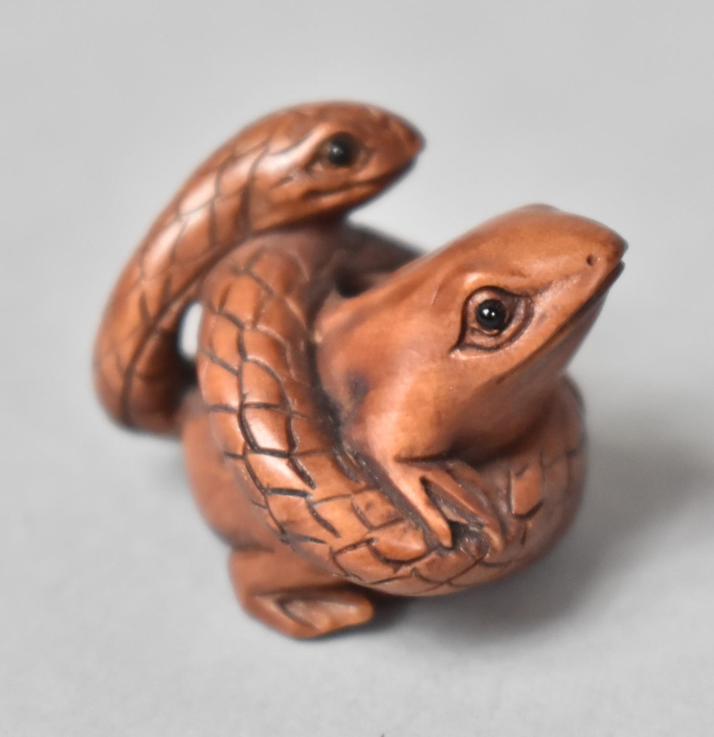 A Carved Wooden Netsuke in the form of a Snake Entwining a Frog