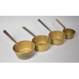 A Collection of Four Graduated Brass Saucepans with Iron Handles