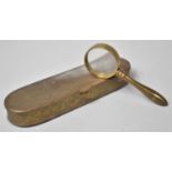 An Oval Brass Tin containing Small Magnifying Glass, Tin 15.5cms Wide