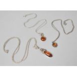 Three Silver and Amber Mounted Pendants on Three Silver Chains