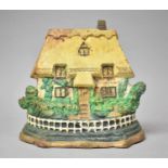 A Reproduction Hand Painted Cast Metal Doorstop in the Form of a Thatched Cottage, 22cm wide