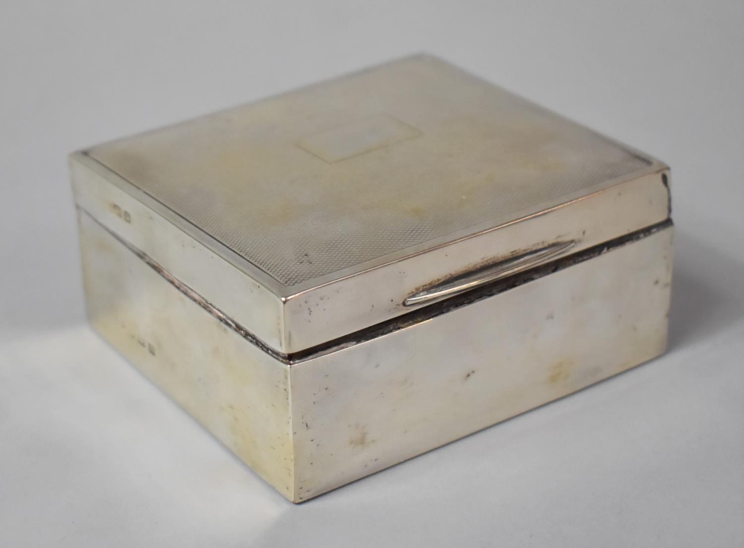 A Silver Cigarette Box with Engine Turned Decoration to Hinged Lid, 10cm wide