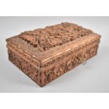 A Richly and Deeply Carved Far Eastern Teak Three Division Box, the Hinged Lid Decorated with