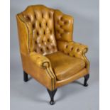 A Tan Leather Buttoned Upholstered Wing Armchair