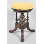 A Late Victorian Circular Swivel Top Piano Stool with Carved Decoration and Turned Supports. 33cms