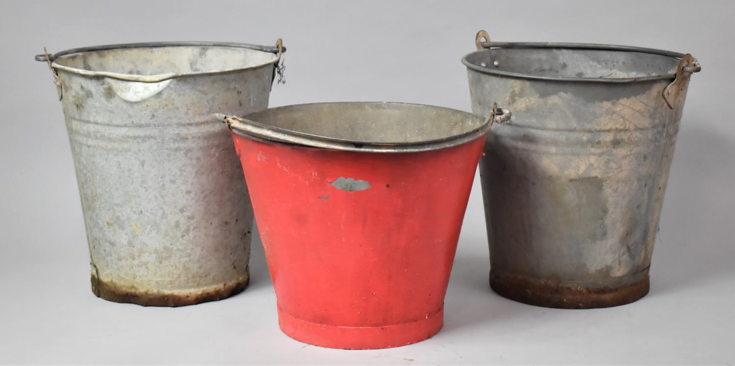 A Collection Three Galvanized Fire Buckets, One Painted Red