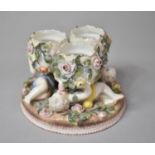 A Late 19th Century German Porcelain Three Section Stand in the Form of Cherubs Supporting Eggs,