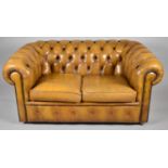 A Tan Leather Chesterfield Two Seater Settee with Buttoned Upholstery, 144cm wide