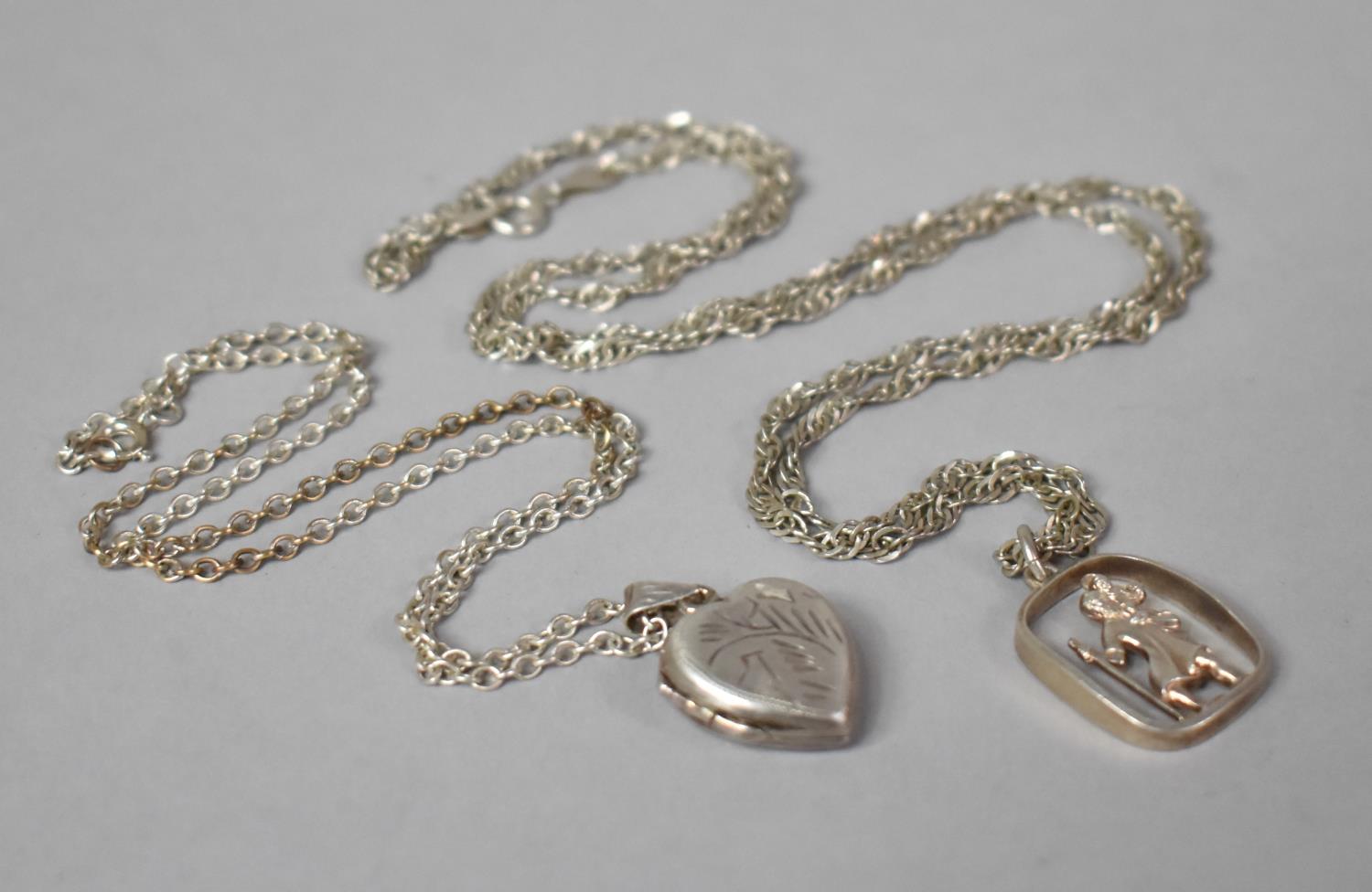 A Silver Heart Shaped Locket Pendant and a St. Christopher Pendant on Silver Chains