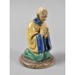 A Small Glazed Stoneware Figure of a Chinese Kneeling Monk, 7cm high