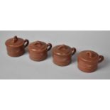 A Set of Four Chinese Yixing Lidded Chocolate Pots with Stylised Bamboo Handles and Incised