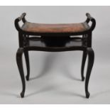 An Edwardian Scroll Arm Piano Stool with Music Undershelf and Hide and Brass Studded Pad Seat,