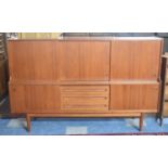 A Danish Teak Sideboard with Three Centre Drawers Flaked by Shelved Cupboard Either Side, Raised