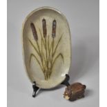 A Small Clay Model of a Cat Together with a Studio Pottery Oval Plate Decorated with Bullrushes,