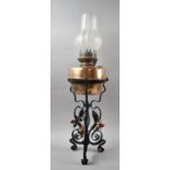 A Mid 20th Century Wrought Iron and Copper Mounted Tripod Oil Lamp with Opaque Shade, 68cm high