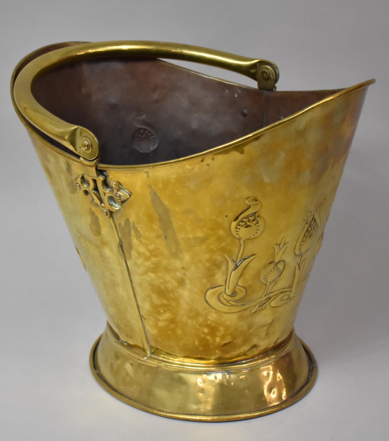 A Brass Helmet Shaped Coal Scuttle with Pressed Art Nouveau Floral Decoration, 33cm High