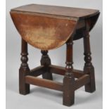 A Small Oak Oval Top Drop Leaf Occasional Table on Turned Supports, 51cm Long and 50cm high