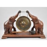 A Carved Wooden Indian Souvenir Gong on Stand, Supports in the Form of Elephants, Plinth Base with