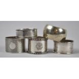 A Collection of Four Silver and One Metal Napkin Rings