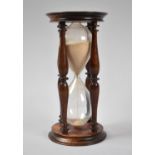 A Modern Mahogany Hourglass of Circular Form, 16cm high