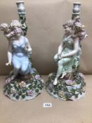 TWO 19TH CENTURY LARGE PORCELAIN CANDLESTICKS FIGURES SEATED WITH CHERUBS AND FLOWERS, CONTINENTAL