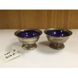 A PAIR OF SILVER SALTS ON PEDESTAL BASE WITH BLUE LINERS 1929 ROBERT BELK LTD 84 GRAMS