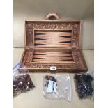 A VINTAGE DECORATIVE CARVED WOOD SUITCASE CHESS AND BACKGAMMON GAME SET