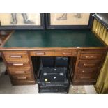 AN ART DECO OAK DESK WITH SEVEN DRAWERS WITH GREEN LEATHER TOP 152w x 85d x 76h cm