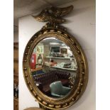 A LARGE GILDED CONVEX BEVELLED MIRROR WITH AN EAGLE ON TOP 132 X 92CM