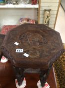 AN ORNATELY CARVED SIDE TABLE WITH A CARVED ELEPHANT IN THE TOP