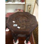 AN ORNATELY CARVED SIDE TABLE WITH A CARVED ELEPHANT IN THE TOP